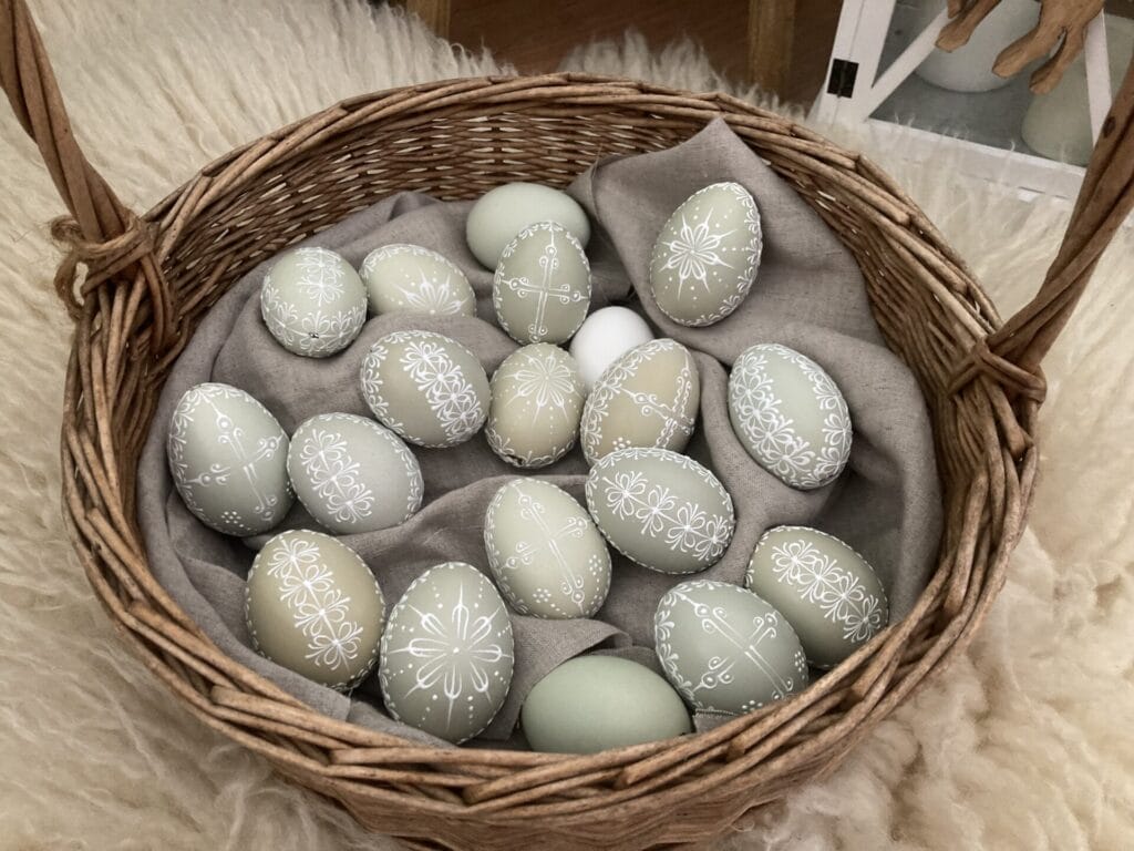 Ručne vyrobený pastelový prútený košík so zdobenými vajíčkami.