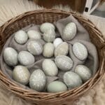 Ručne vyrobený pastelový prútený košík so zdobenými vajíčkami.