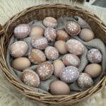 Ručne vyrobené hnedé vajíčka s bielymi vzormi, prútený košík.