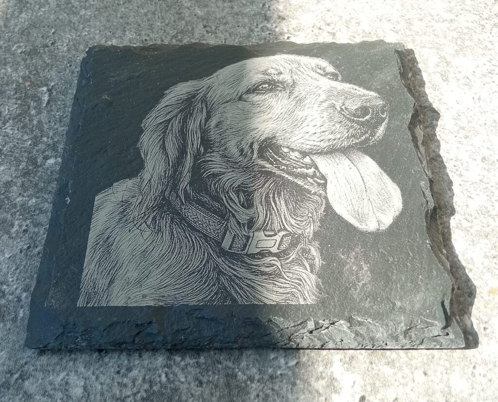 Ručne vyrobená plaketa s portrétom psa zo sivého kameňa.