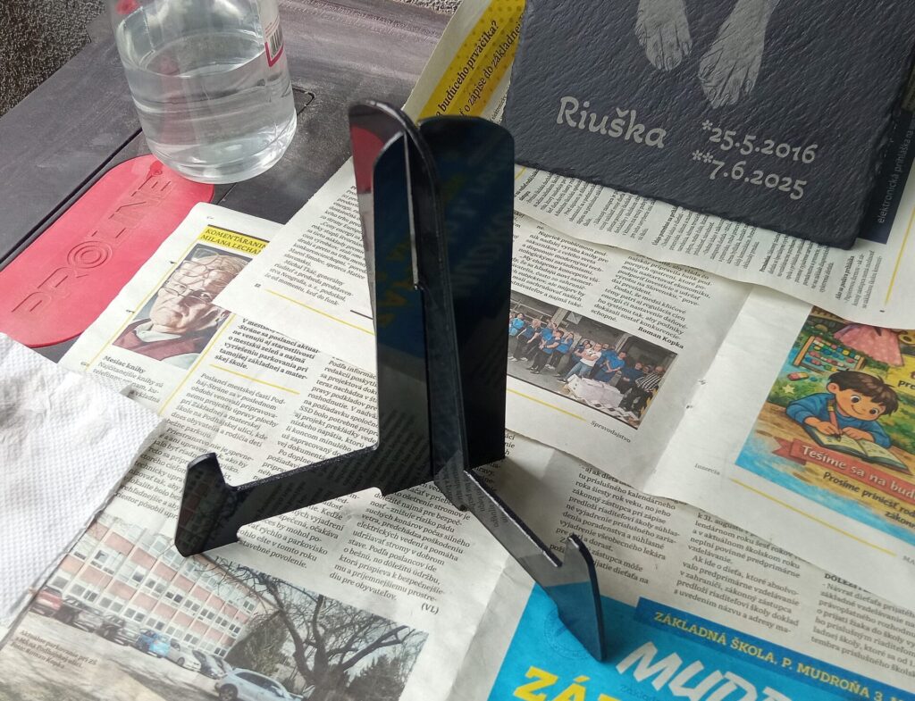 Ručne vyrobený čierny plastový stojan.